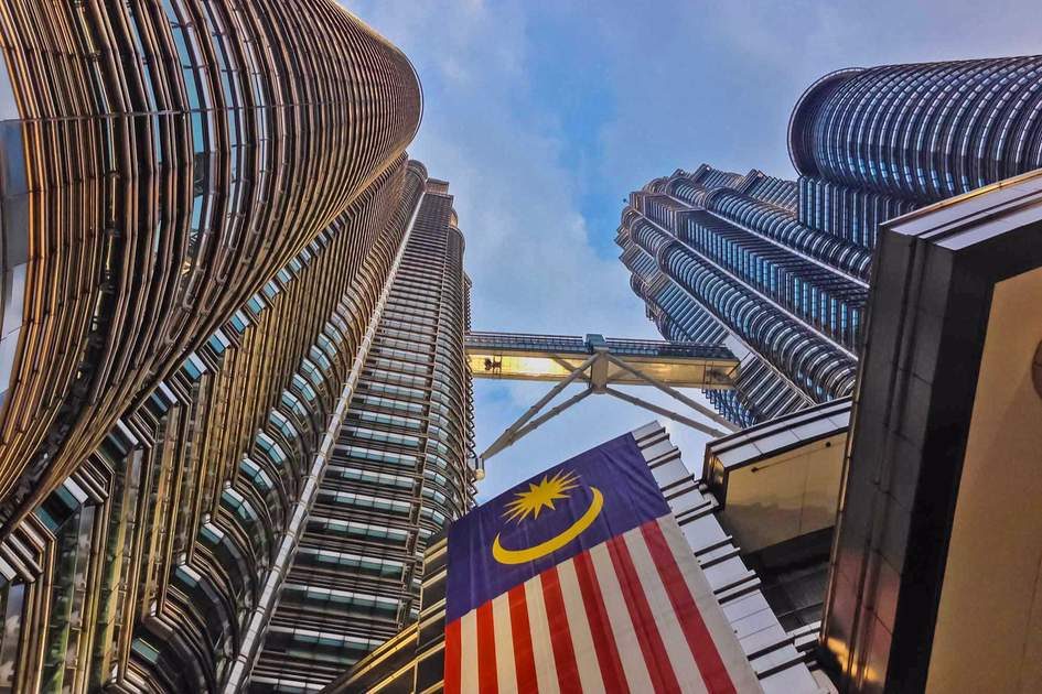 Malaysian flag flying with the Petronas Towers in the background