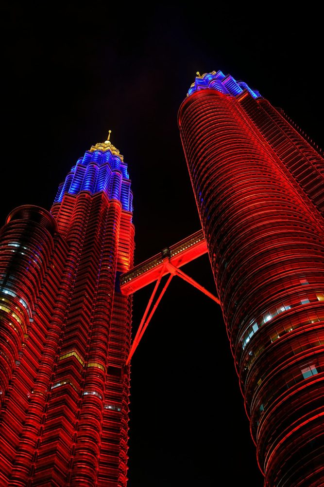 Tall dramatic night shot of both Petronas towers