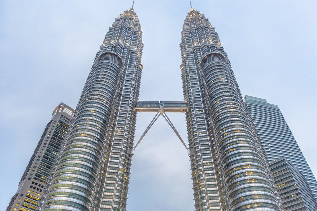 Creative composition showing the Petronas Towers framed through trees and urban elements