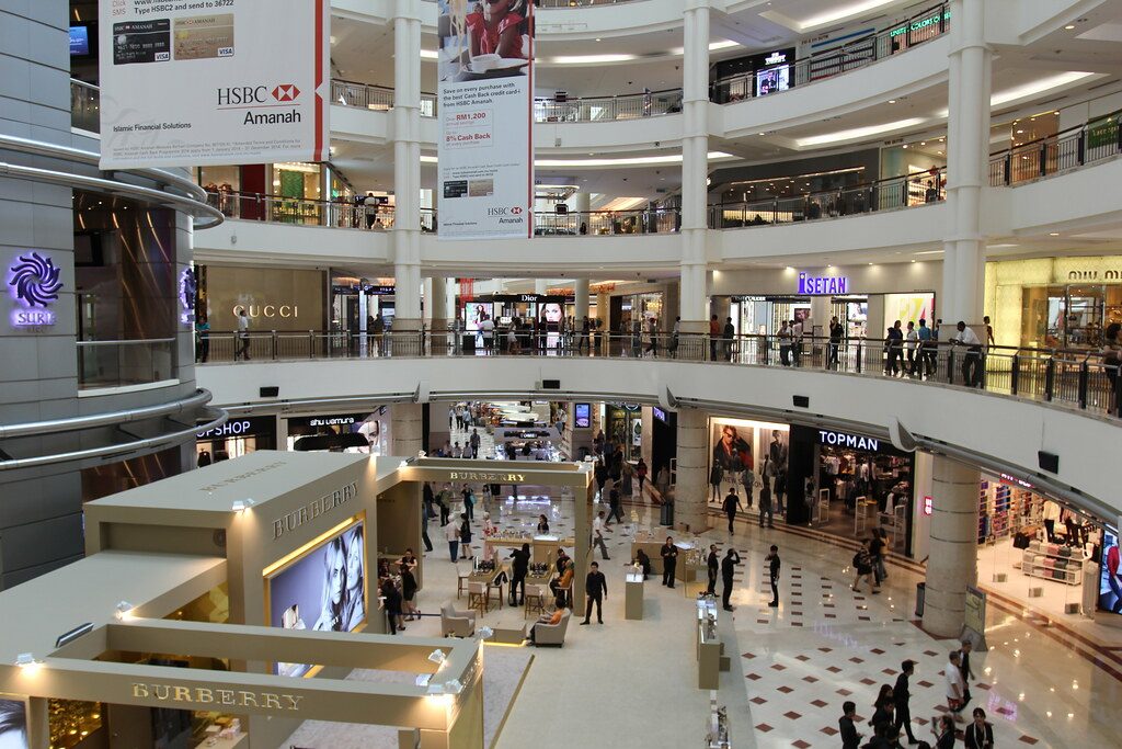 Wide interior view of Suria KLCC showing shoppers and illuminated corridors