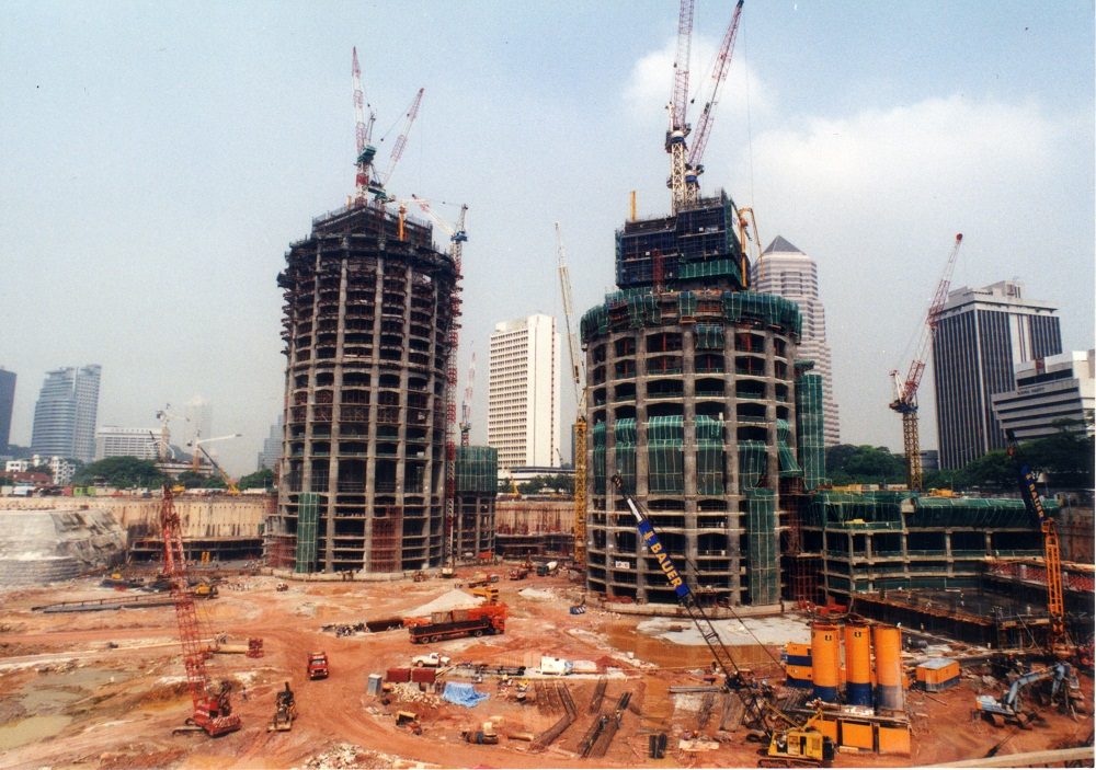 Construction progress of the Petronas Towers showing both towers partially built