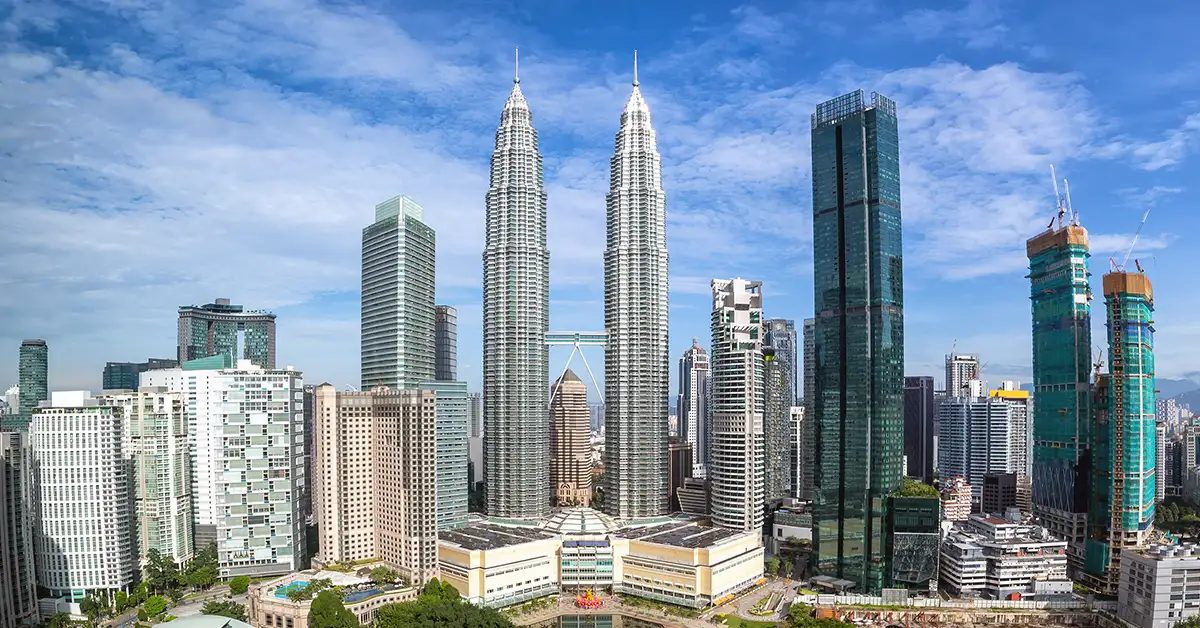 Wide-angle view of the Petronas Twin Towers from street level